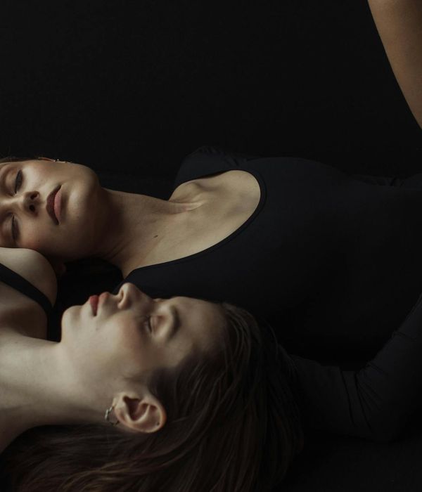 Woman in a calm yoga pose in a studio with soft lighting.